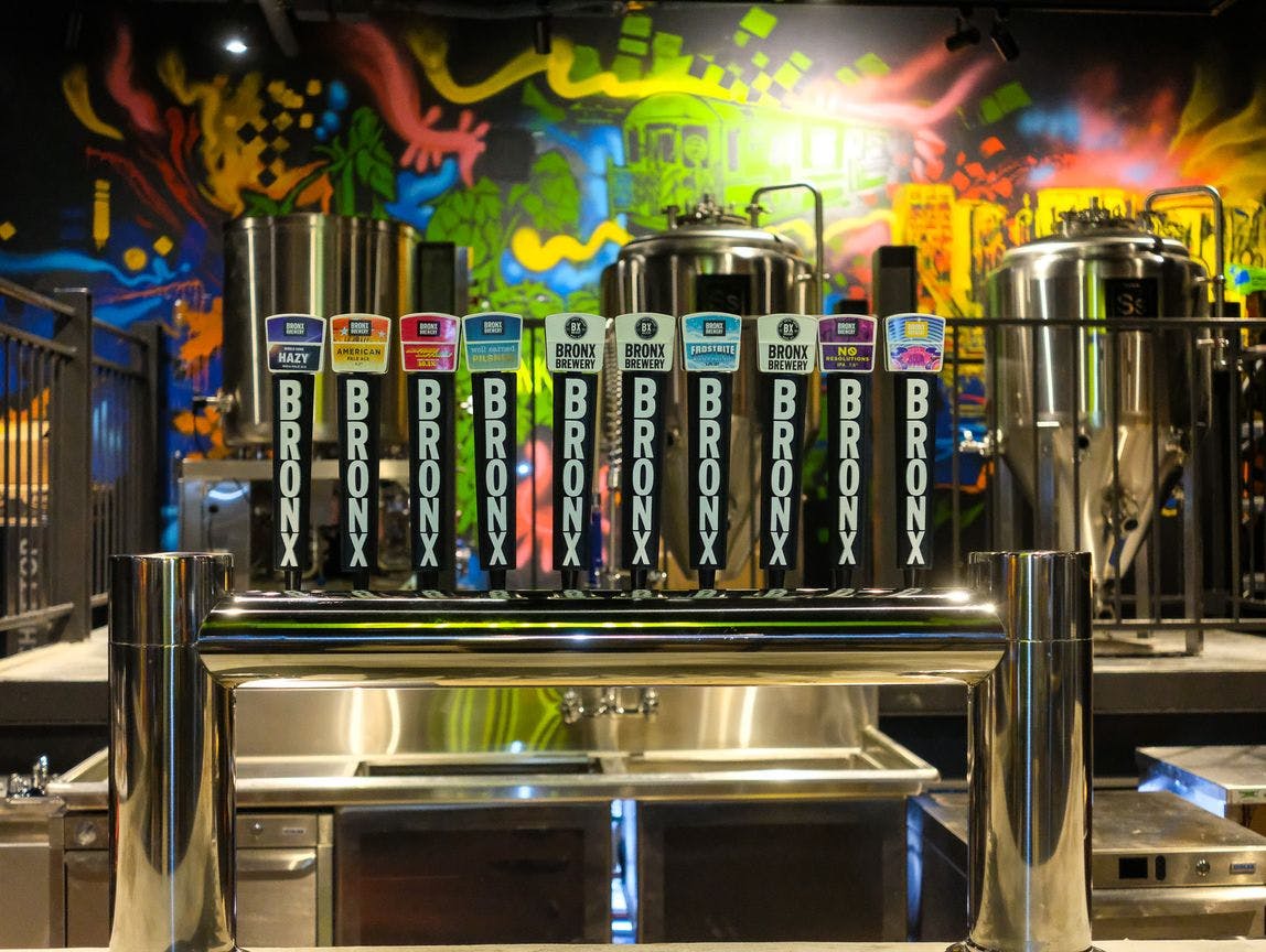 The Bronx Brewery taps with a colorful mural in the background